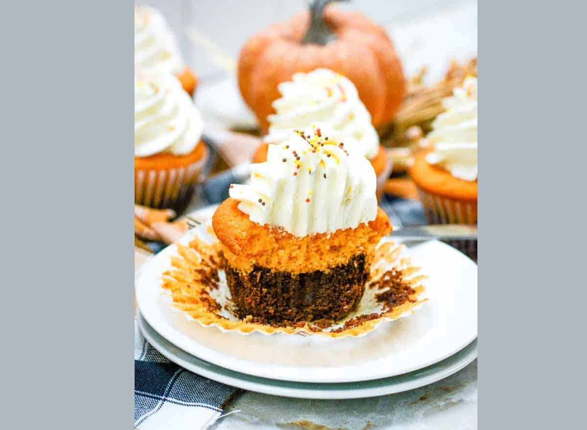 Fall brownie cupcakes with whipped cream on a plate.