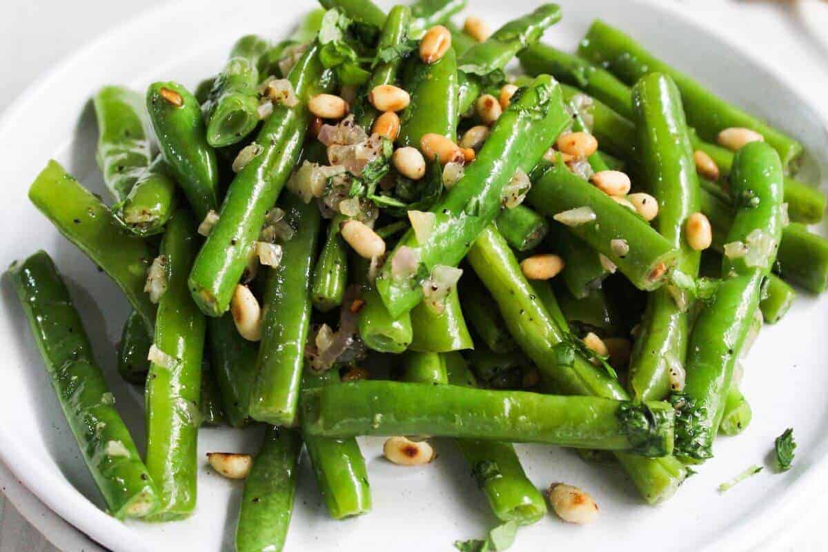 Green beans with pine nuts on a plate.