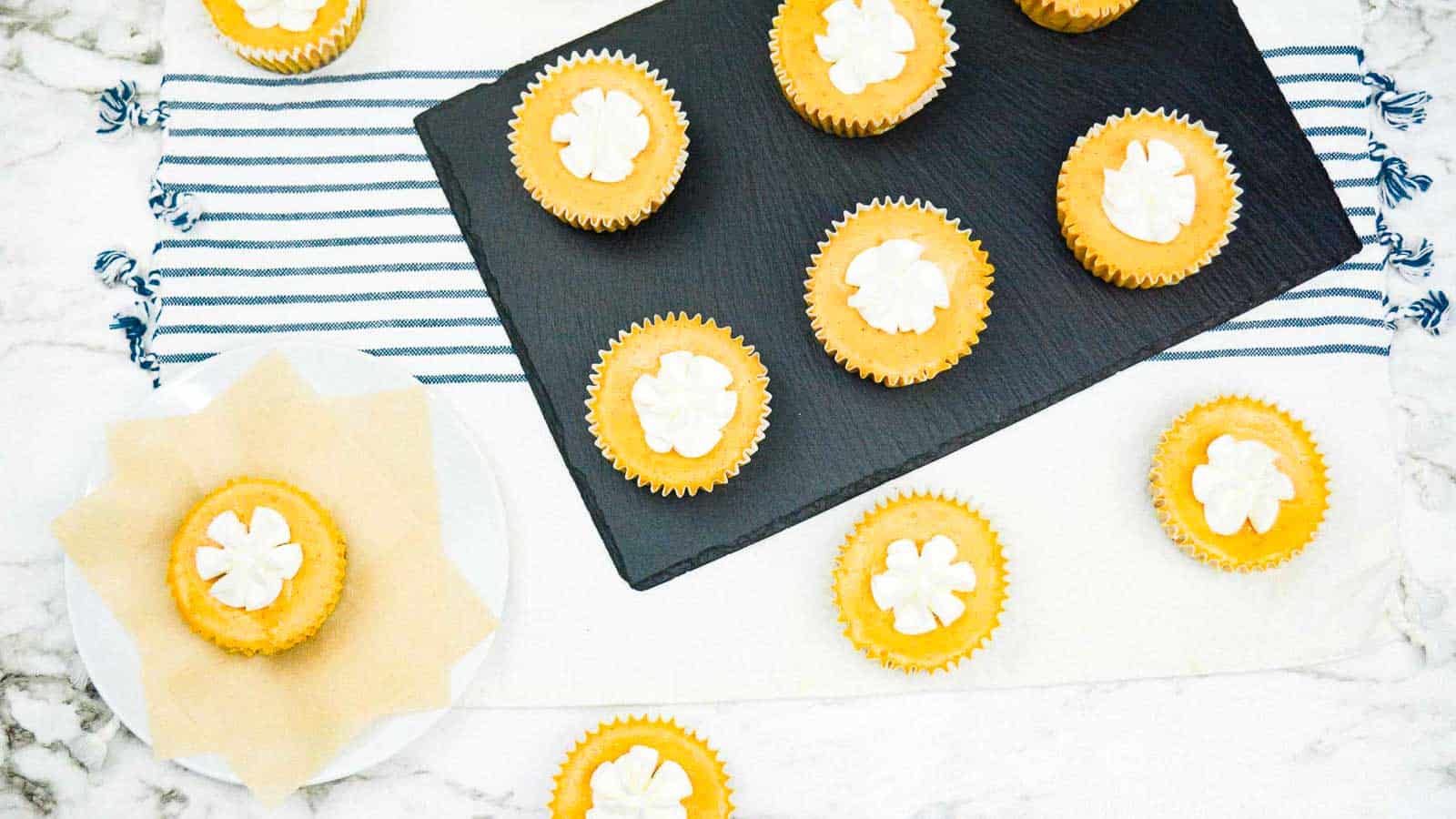 Mini Pumpkin Cheesecakes with whipped cream stars on top.