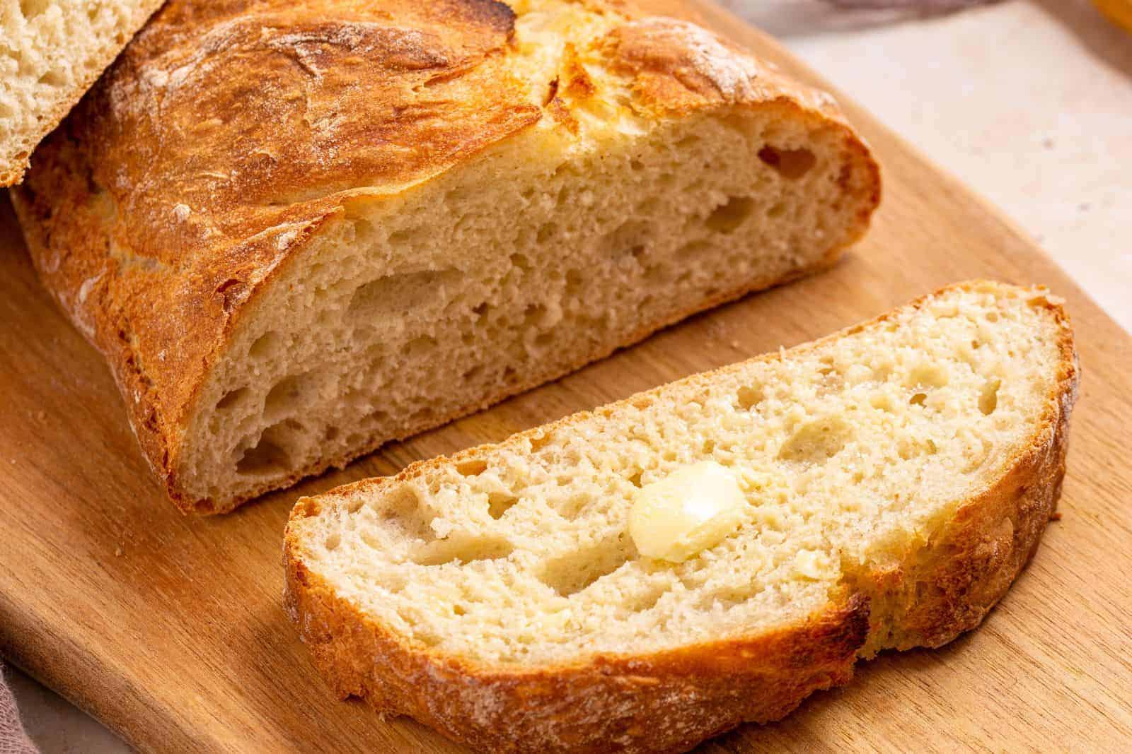 Loaf of artisan bread on wood cutting board.