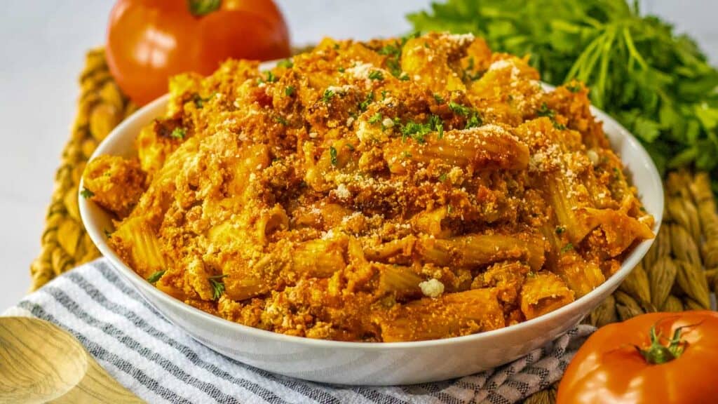 A bowl of baked ziti with meat and tomatoes.