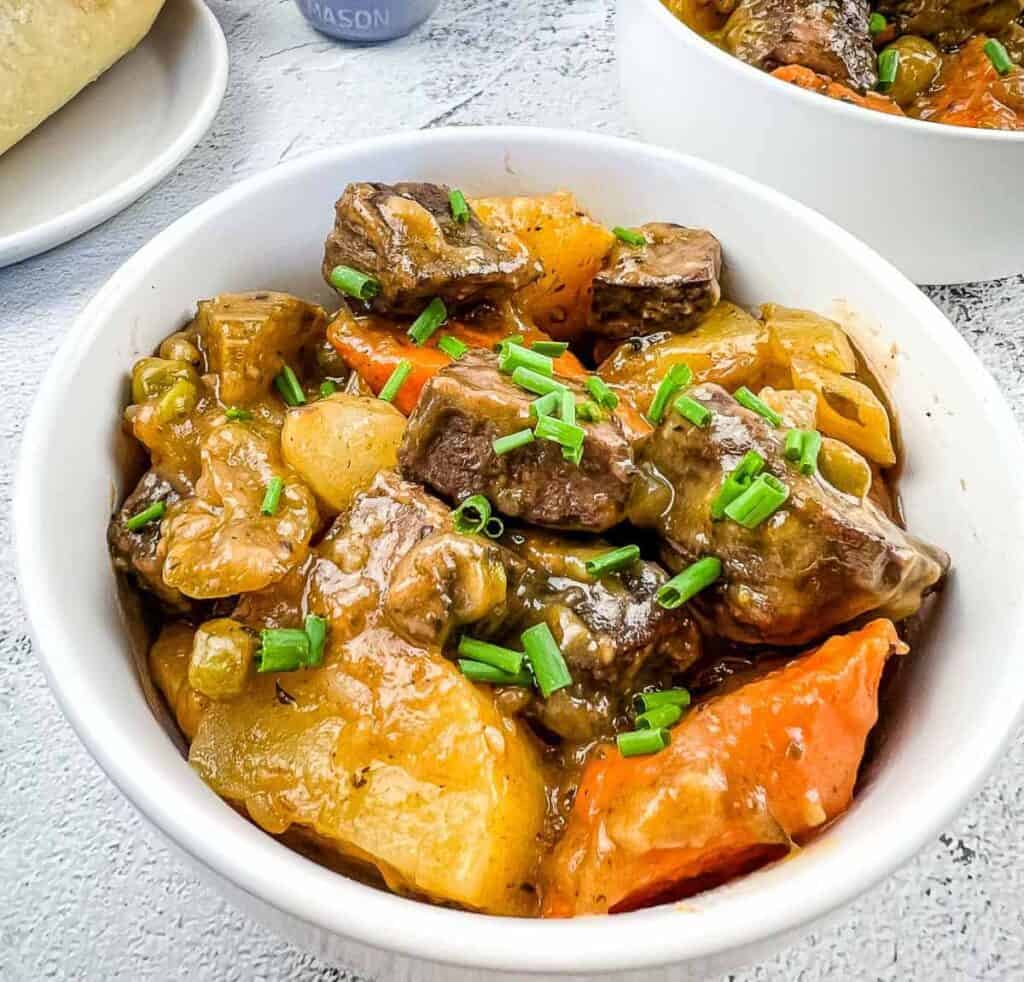 A bowl of beef stew with carrots and potatoes.