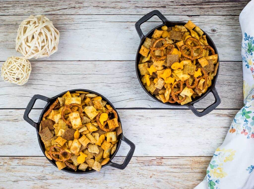 Spicy Chex Mix in 2 black bowls.