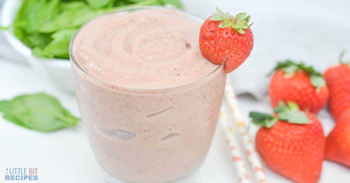 Side view of spinach strawberry smoothie in glass.