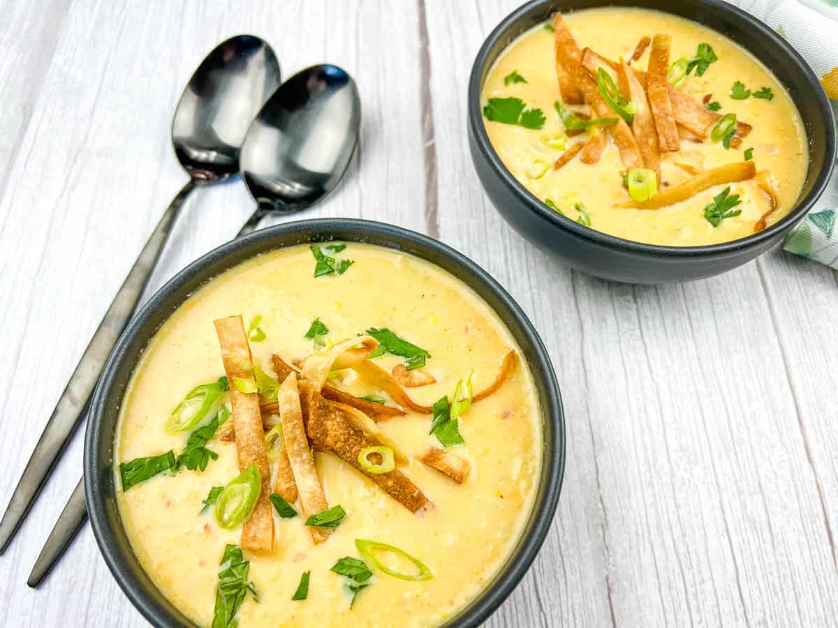 Mexican street style corn soup in a white bowl on a white plate.