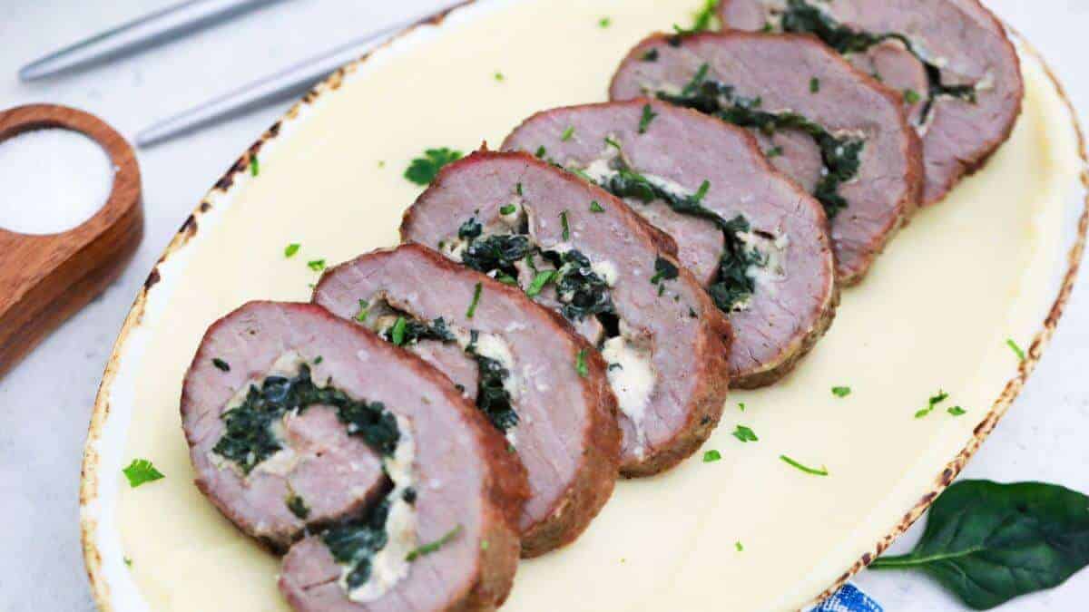 Stuffed steak pinwheels sliced on platter.