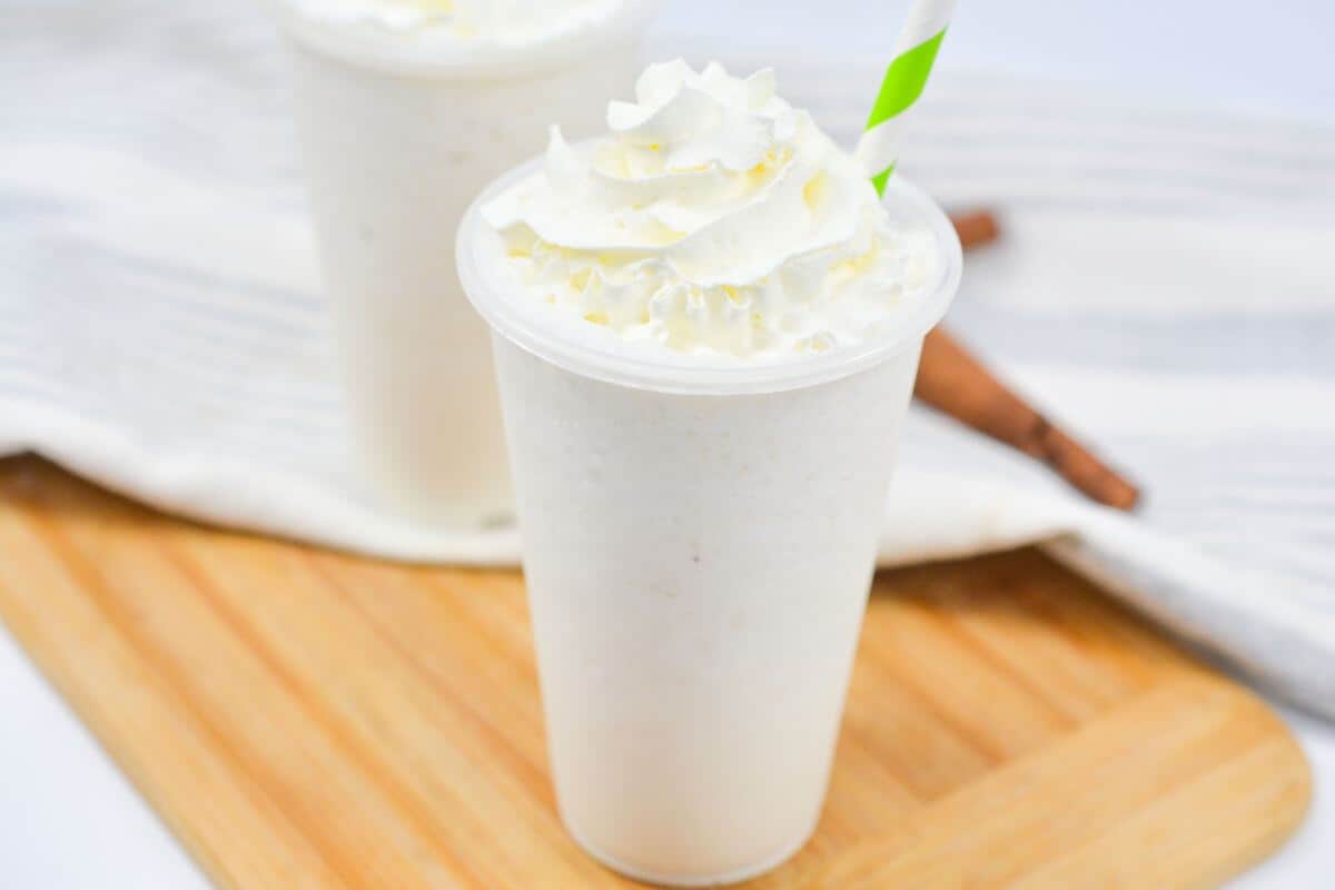 Vanilla bean Frappuccino drinks on a wood cutting board.