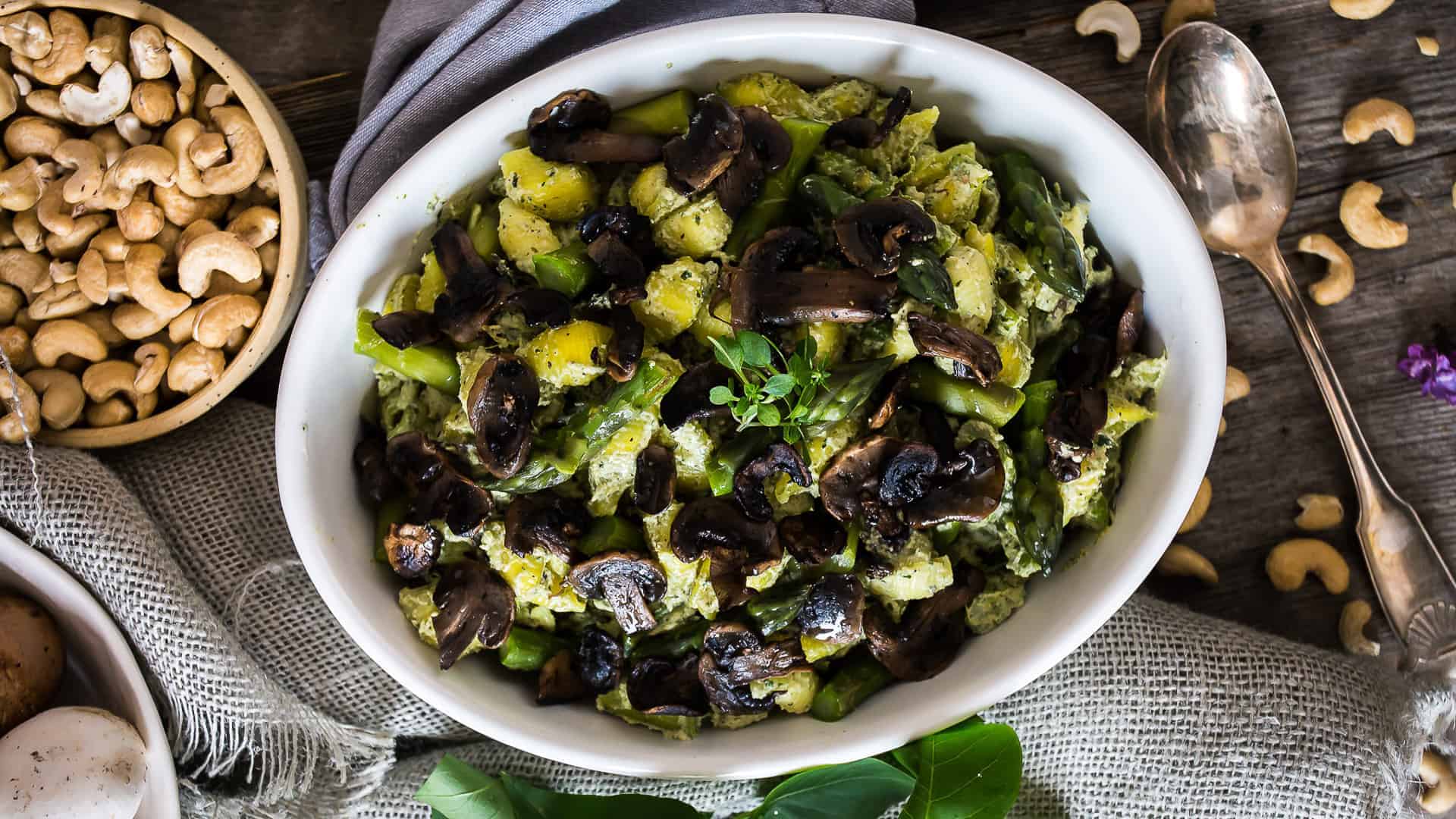 Overhead of pasta with mushrooms and green goddess sauce.