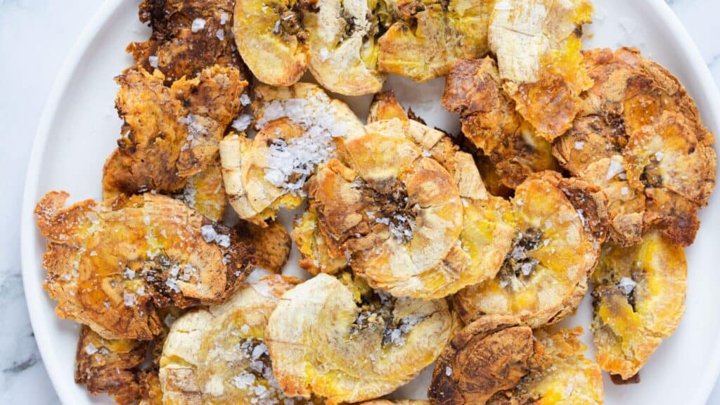 Fried banana chips on a white plate.