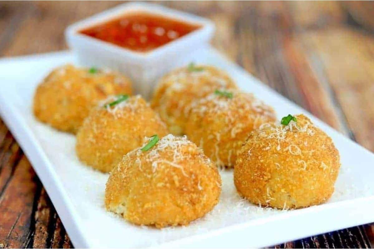 Arancini balls on a white plate.