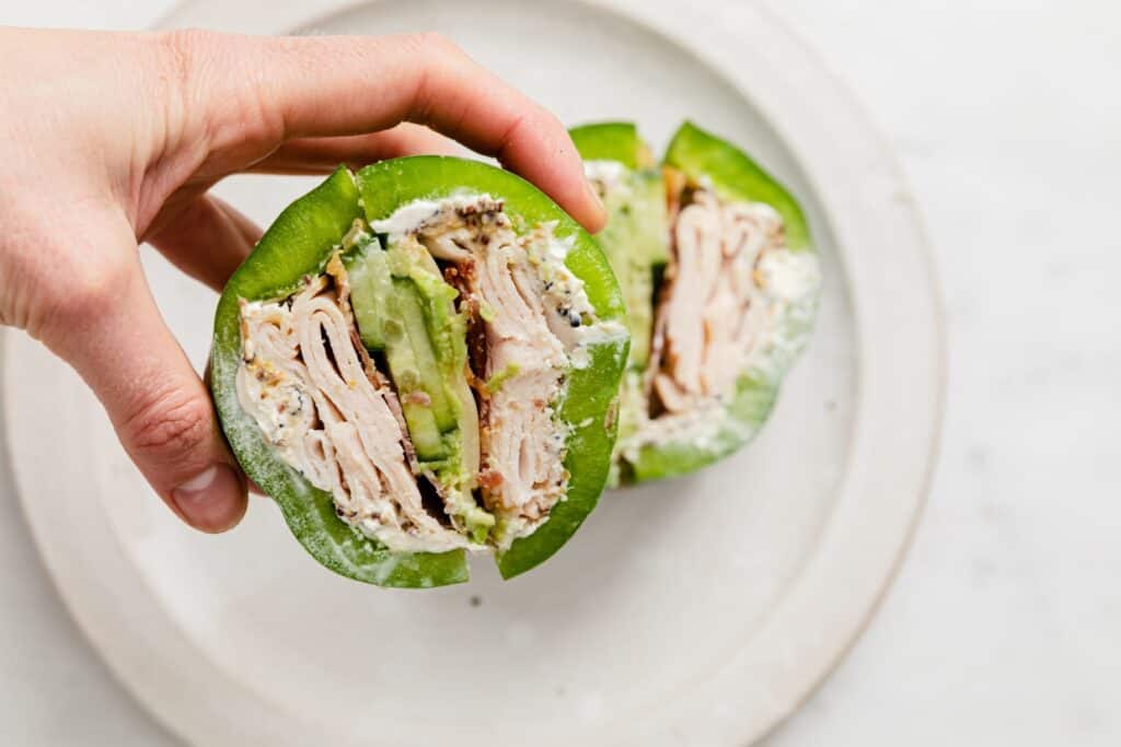 Bell pepper sandwich being held in a hand.