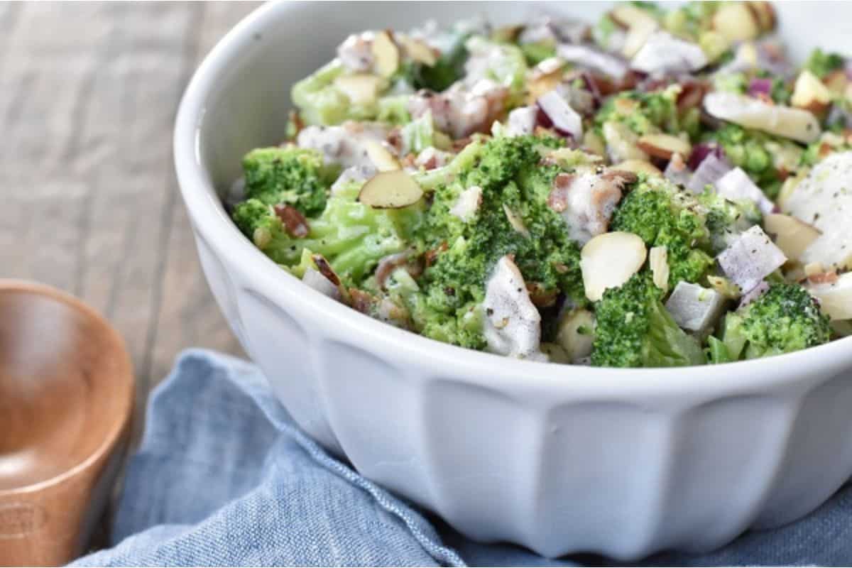 A bowl of broccoli salad with almonds.