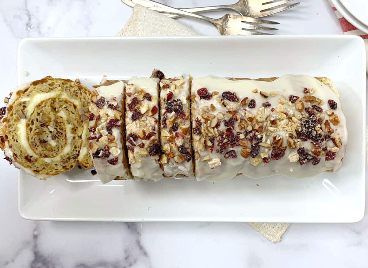 A sliced banana cake roll on a white platter.