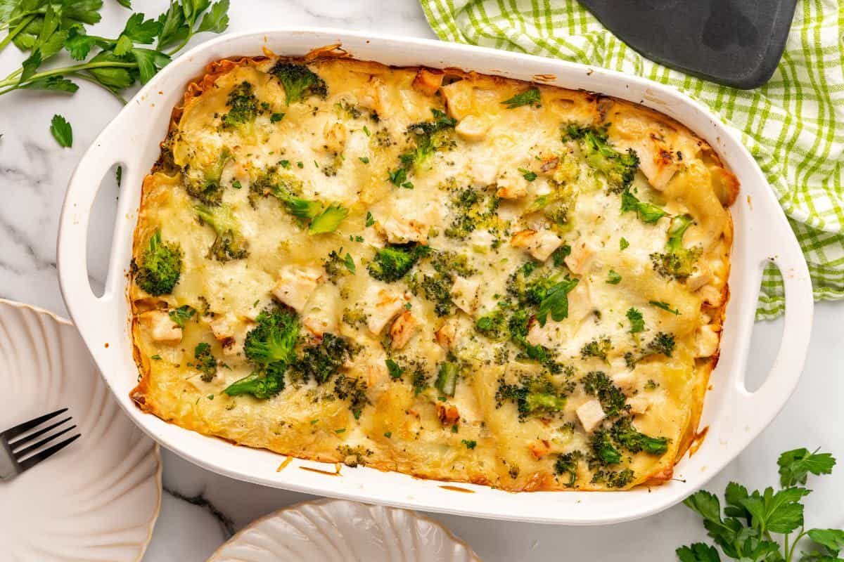 Baked chicken and broccoli pasta in a white 9x13 casserole dish.