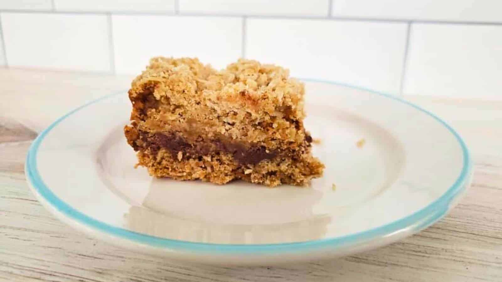 Image shows A piece of chocolate caramel bar on a plate.