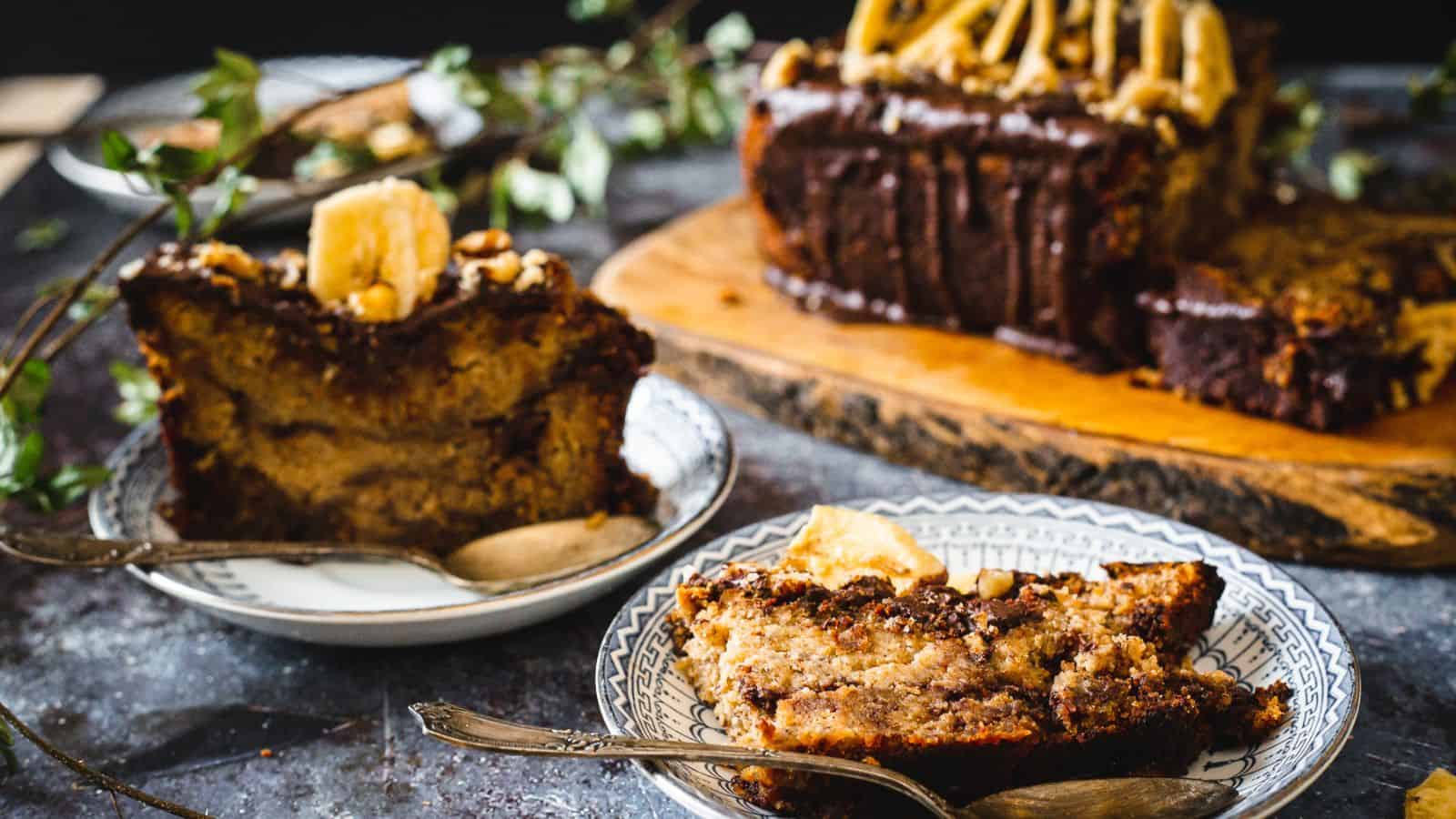 Two slices of banana bread with chocolate and one loaf in background.