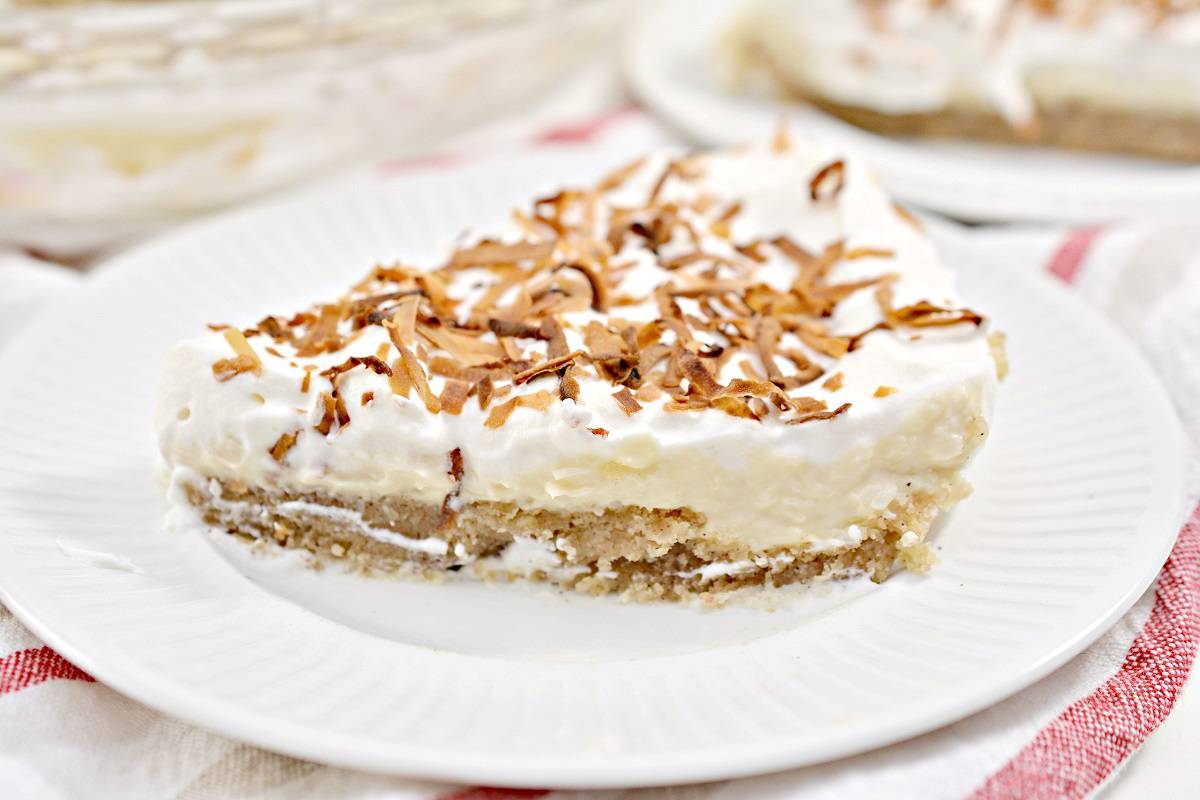 A slice of coconut cream pie on a plate.