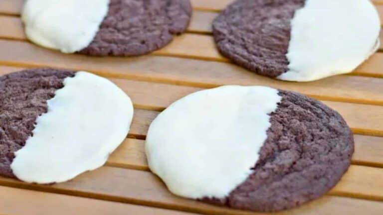 Image shows four Copycat Mrs. Field's Chocolate Dipped Cookies on a wooden table.