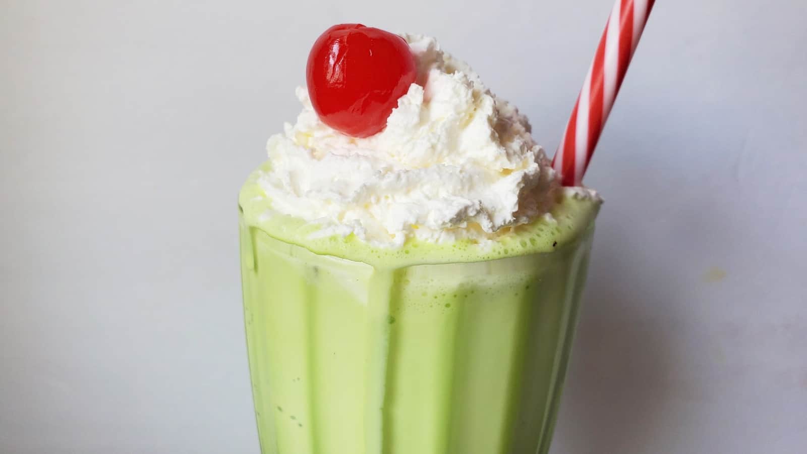 Image shows a Copycat shamrock shake with whipped cream and cherry.