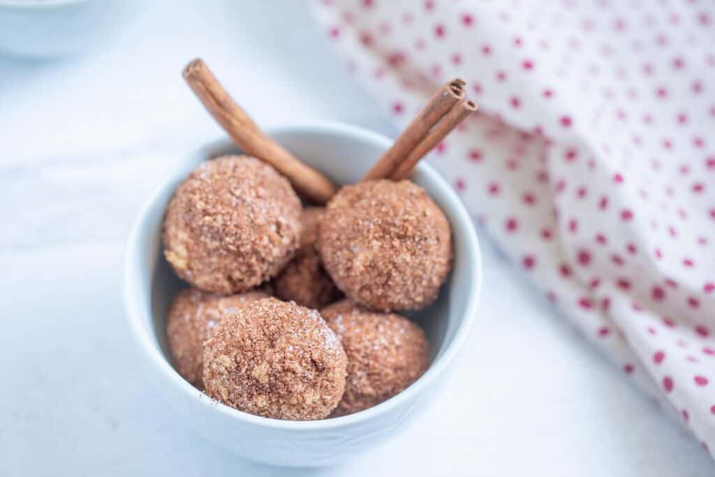 Churro balls in a white bowl.