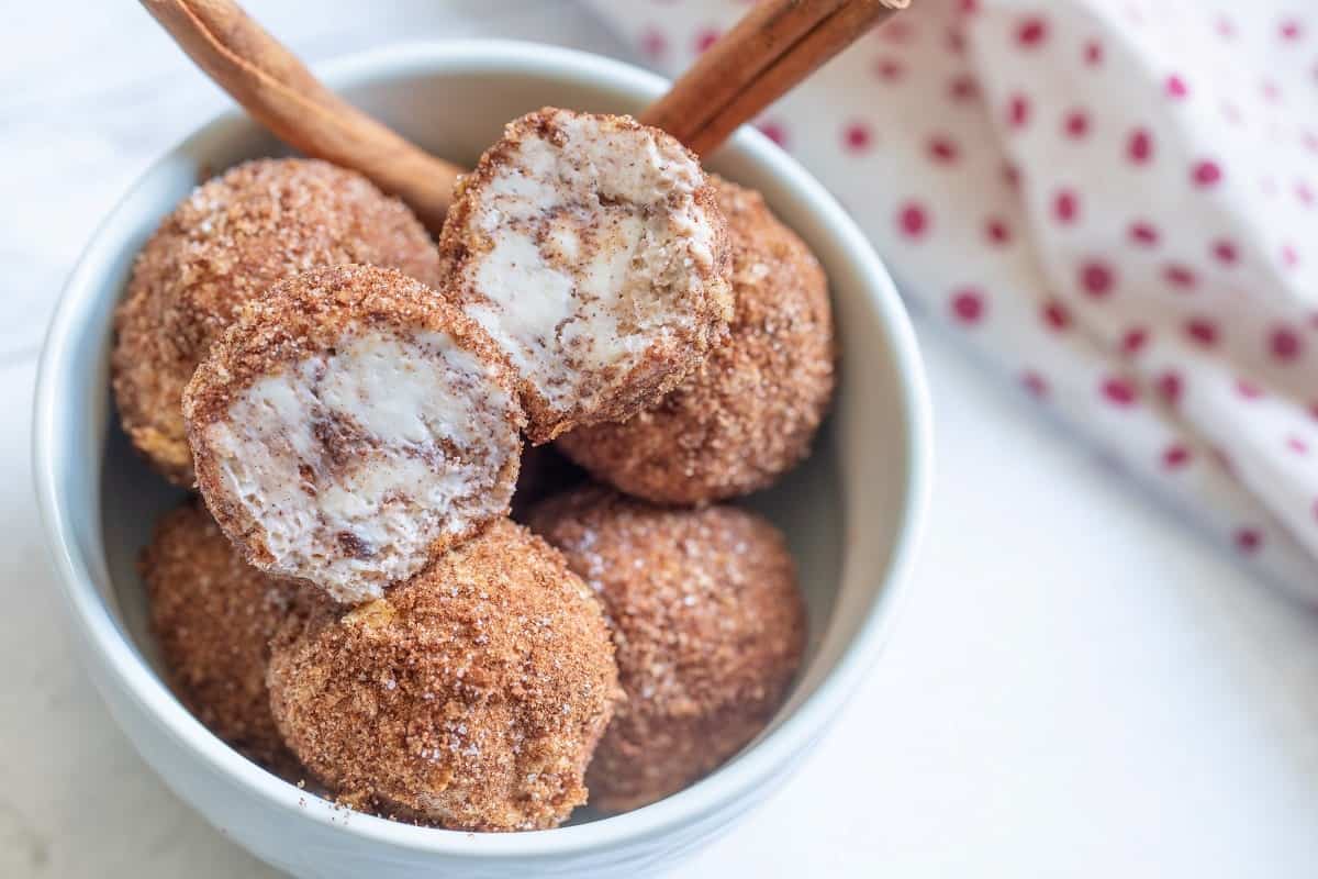 Churro balls in a white bowl.