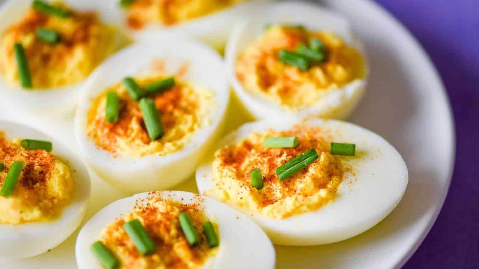 Deviled eggs on a plate with green onions.