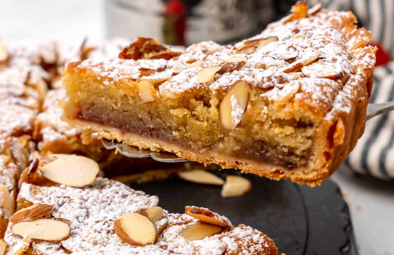 A slice of a strawberry jam Bakewell tart.