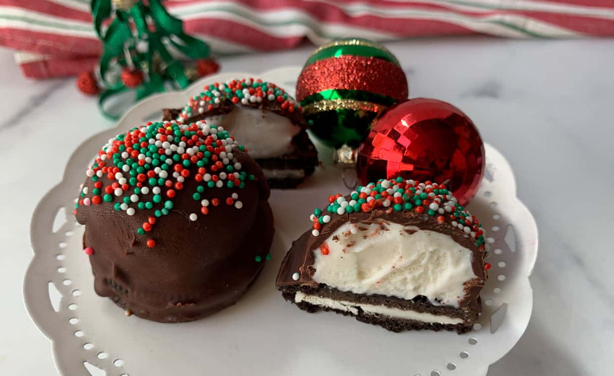 Chocolate covered ice cream bites on a piece of parchment paper.