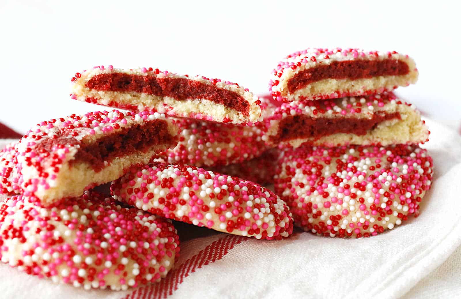 Red velvet stuffed cookies on a white and red towel.