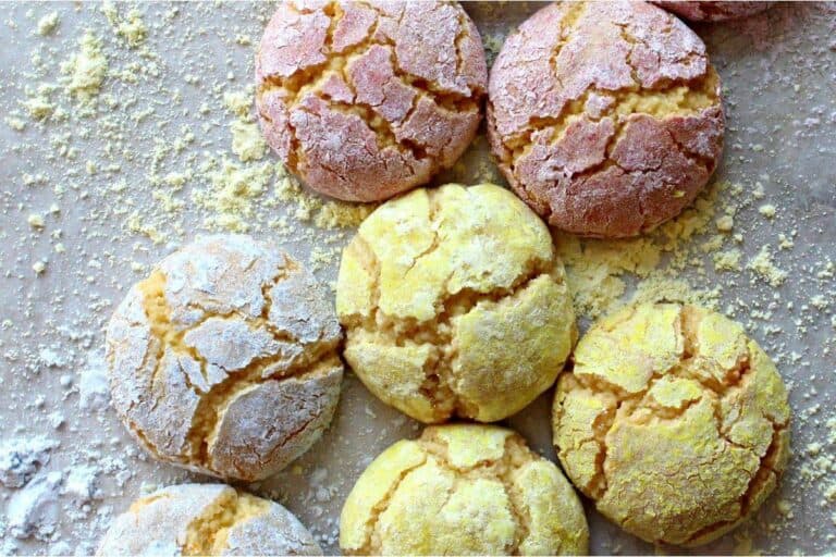 Crinkle cookies with powdered sugar on a baking sheet.