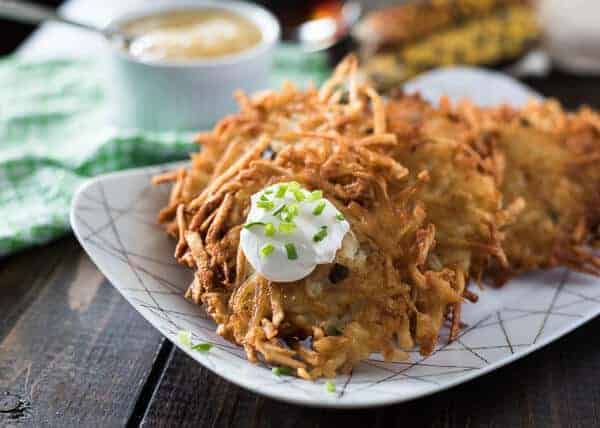 German potato pancakes, known as kartoffelpuffer, served on a plate with sour cream and chives.