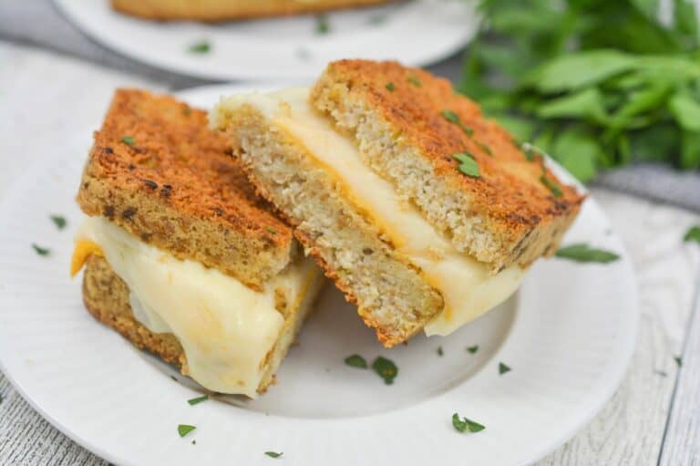 Two slices of grilled cheese on a plate.