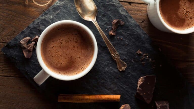 Two cups of hot chocolate on a slate table.