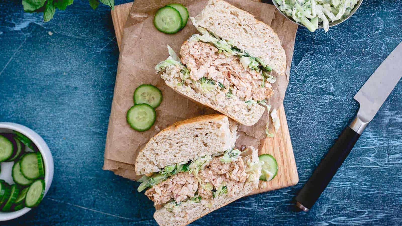 Indian chicken burgers cut in half with cucumber yogurt slaw.