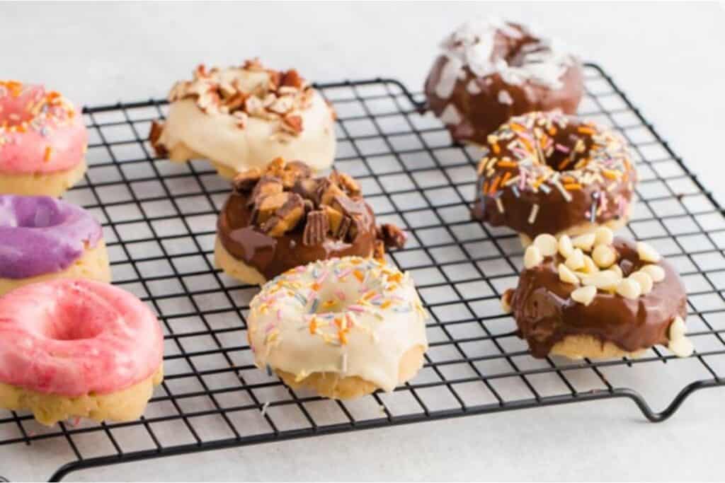 Donuts on a cooling rack with sprinkles.