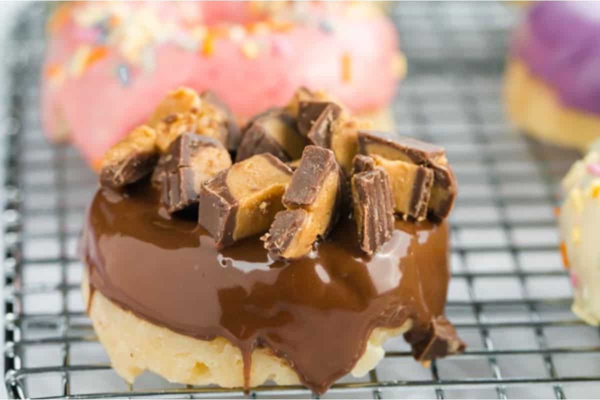 Peanut butter and chocolate donuts on a cooling rack.