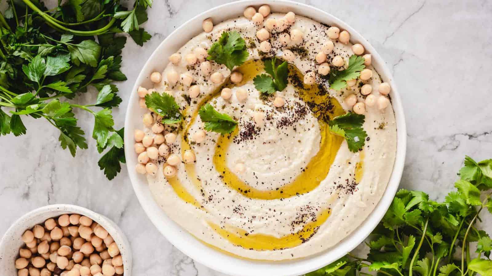 A festive bowl of hummus adorned with fresh parsley and wholesome chickpeas, perfect for holiday appetizers.