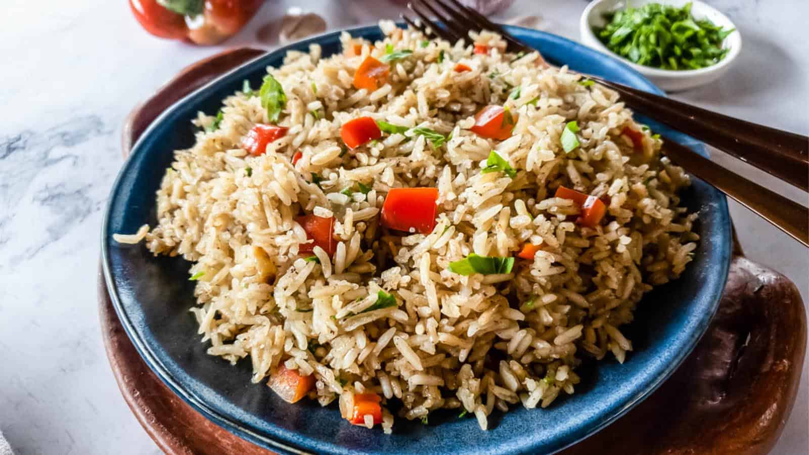 A bowl of Longhorn steakhouse rice with copper forks on a table.