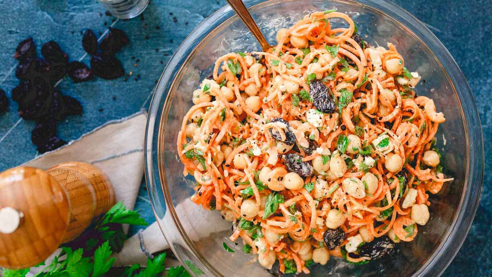 Mediterranean carrot salad with white beans and raisins in a glass bowl.