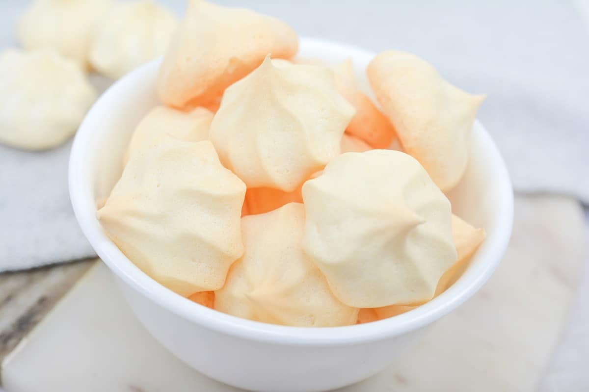 A bowl of meringue cookies in a white bowl.