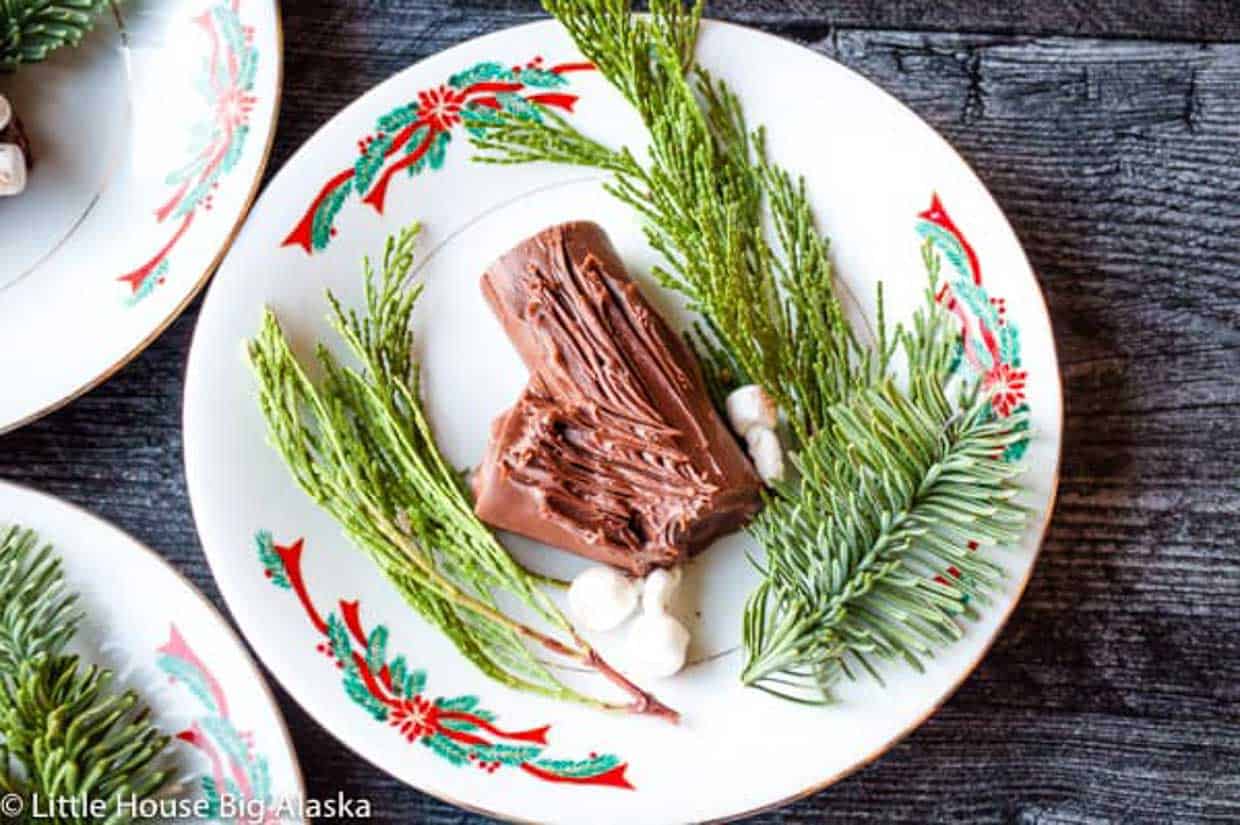 3 mini yule log cakes on Christmas plates.