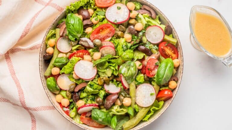 Close up of Nicoise salad with dressing on the side.