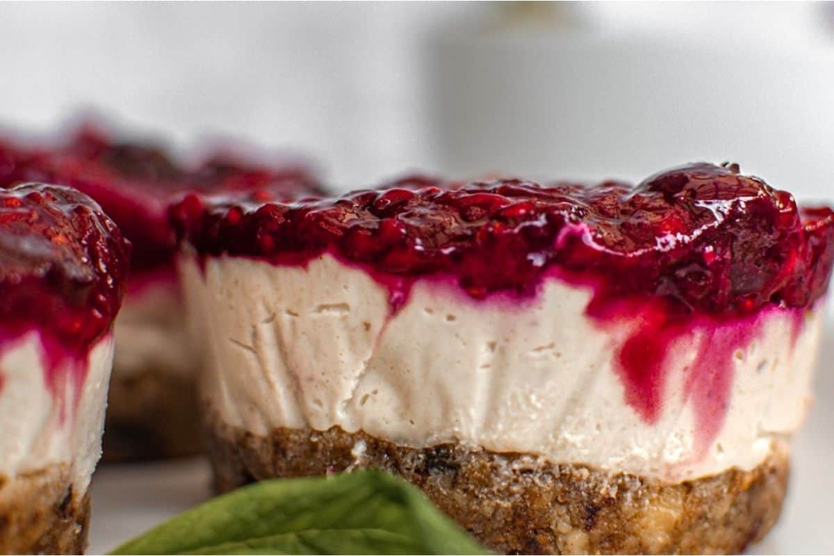 Berry cheesecake bites on a white plate.