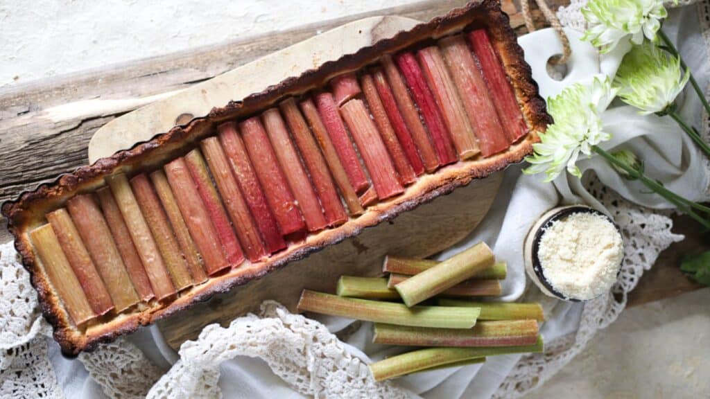 Fruit desserts on a wooden board, featuring a rhubarb tart.