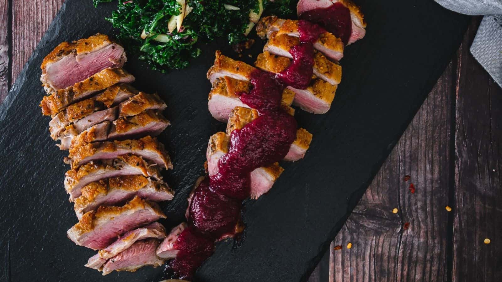 Roasted duck with cranberry sauce and kale.