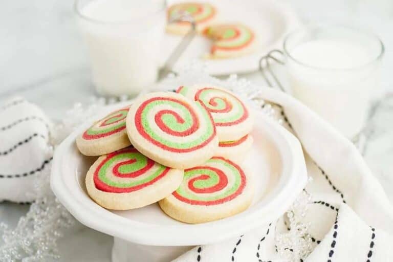 Swirl cookies on a plate with a glass of milk.