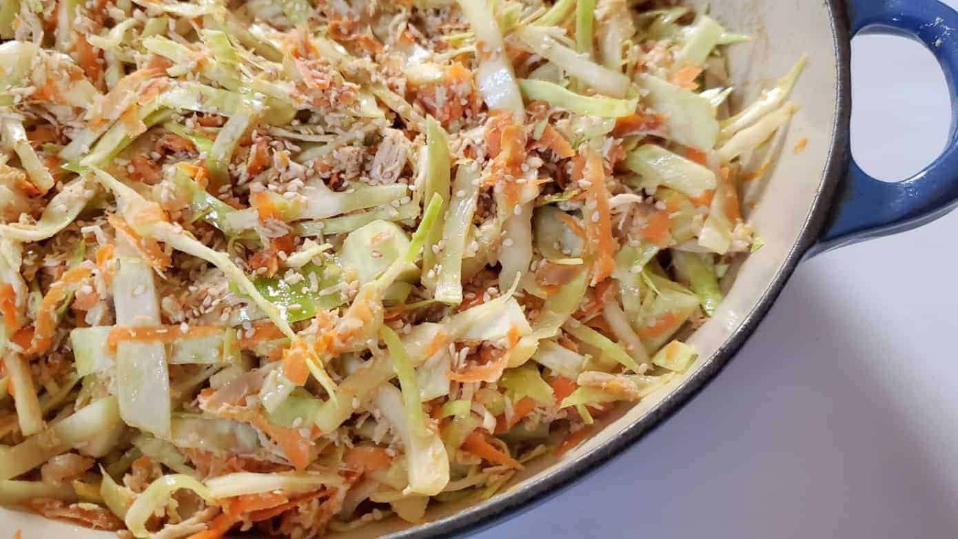 Image shows a closeup of chicken egg roll in a bowl in a blue enameled cast iron pot.