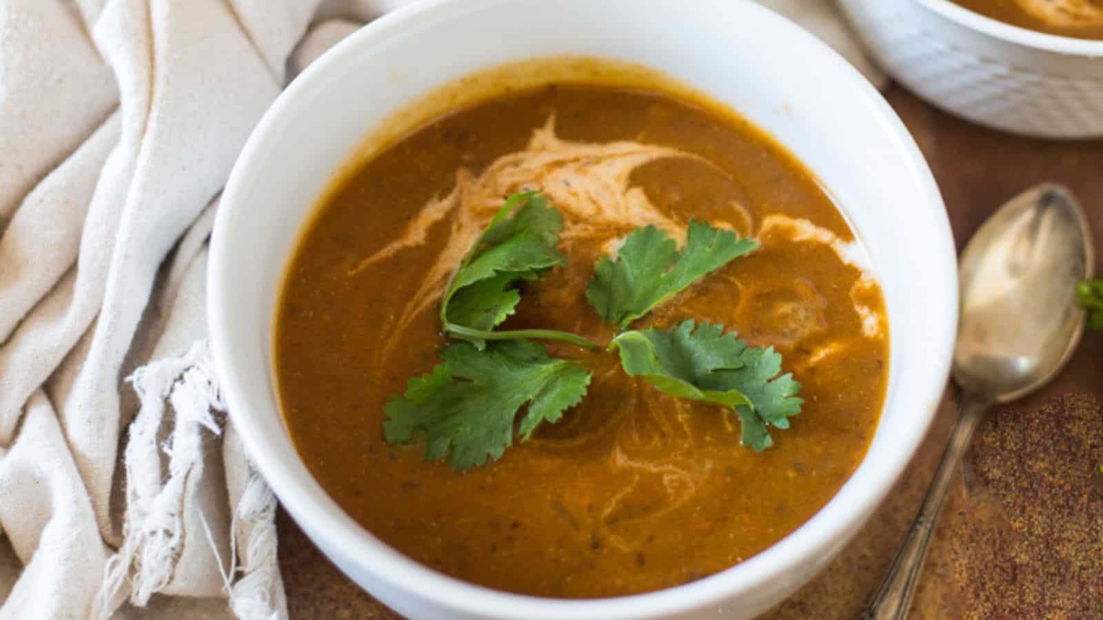 Two bowls of soup on a wooden table.