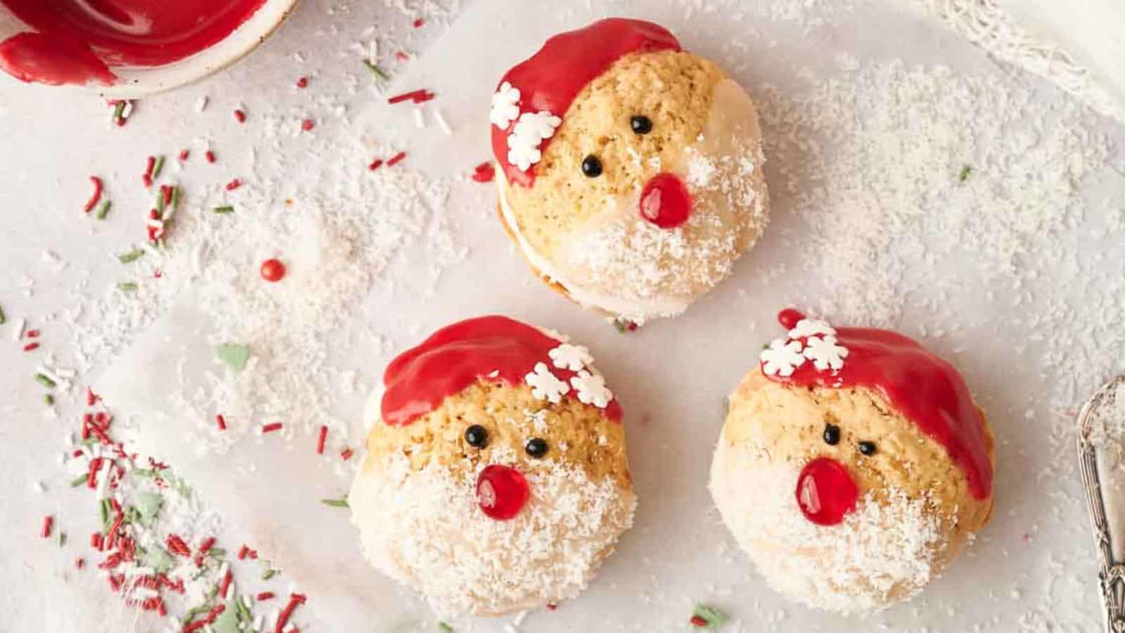 Three Santa Claus whoopie pies on a baking sheet.