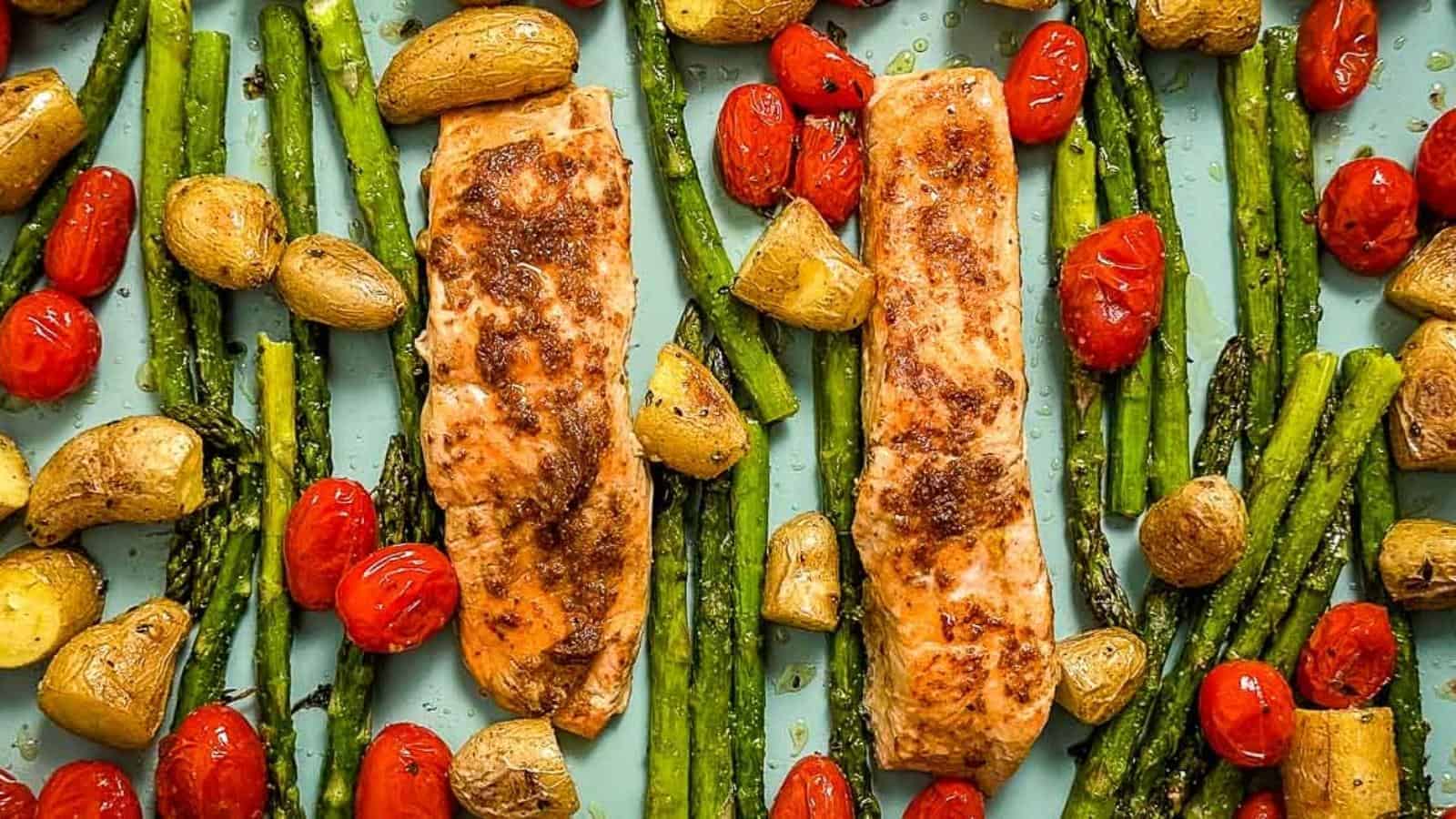 Salmon, asparagus, tomatoes and potatoes on a baking sheet.